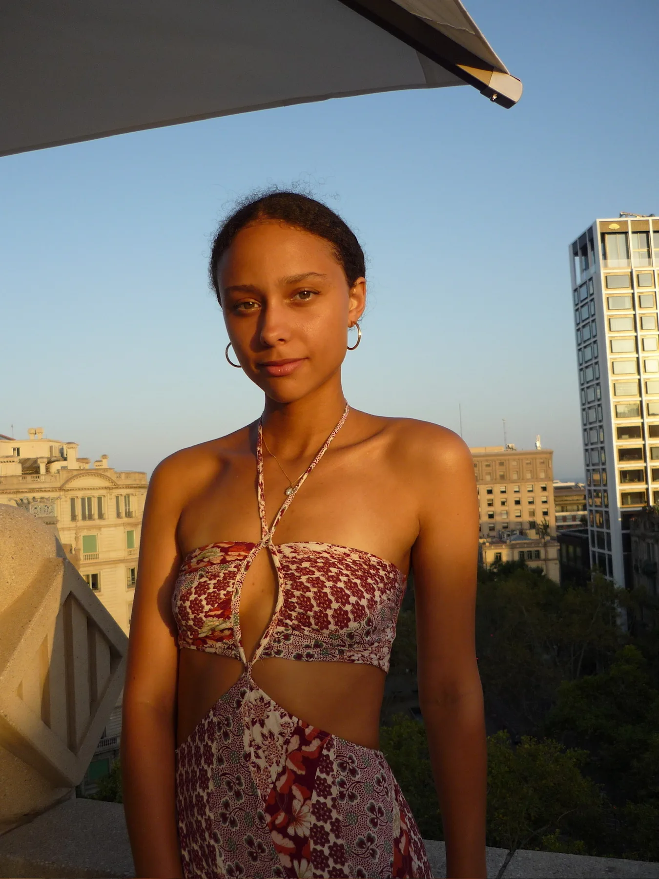 Sophia Coon on a rooftop at golden hour with the city skyline behind her